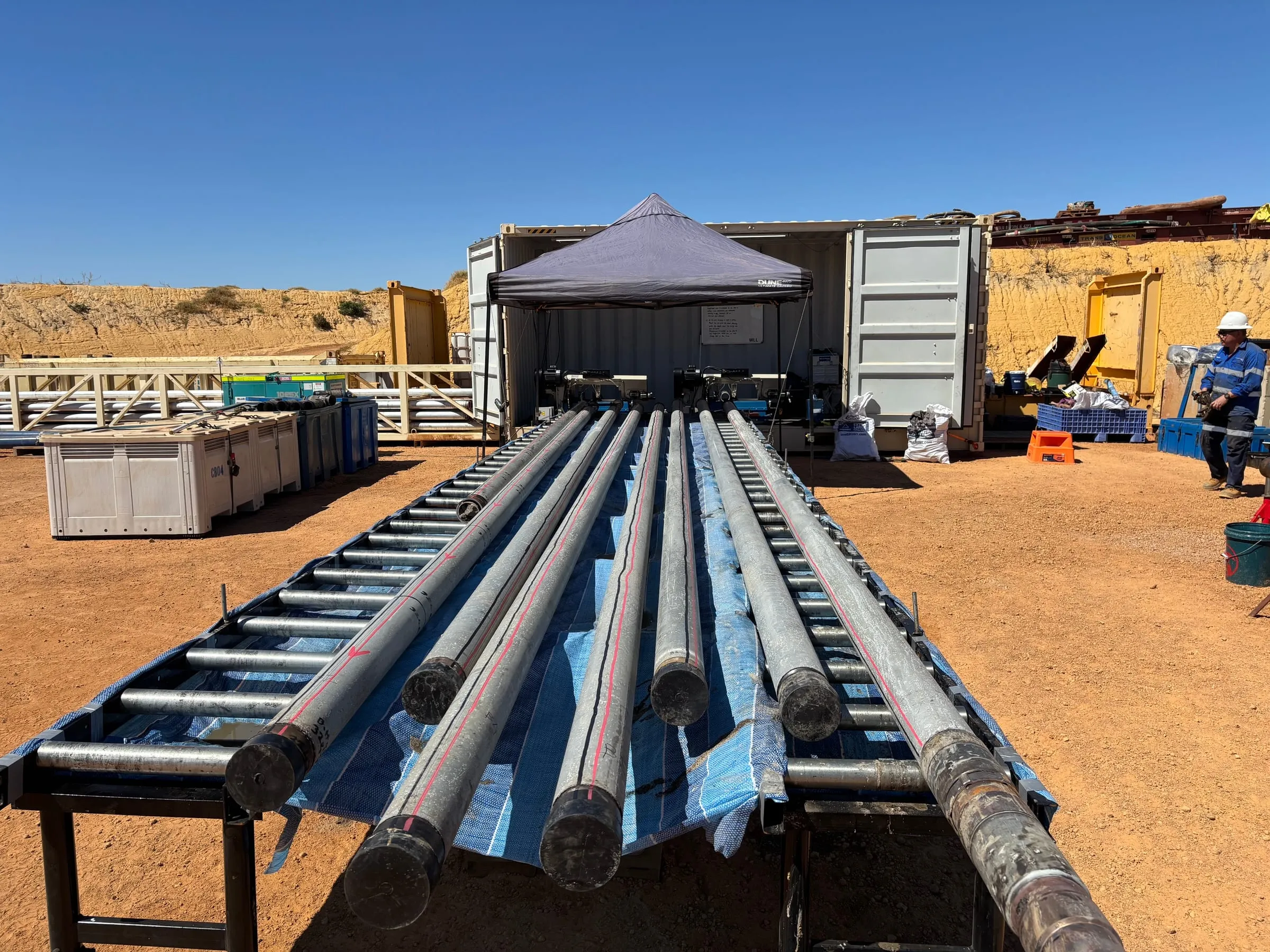 Rows of inner barrels laid out on the SOS roller tables beside the processing container